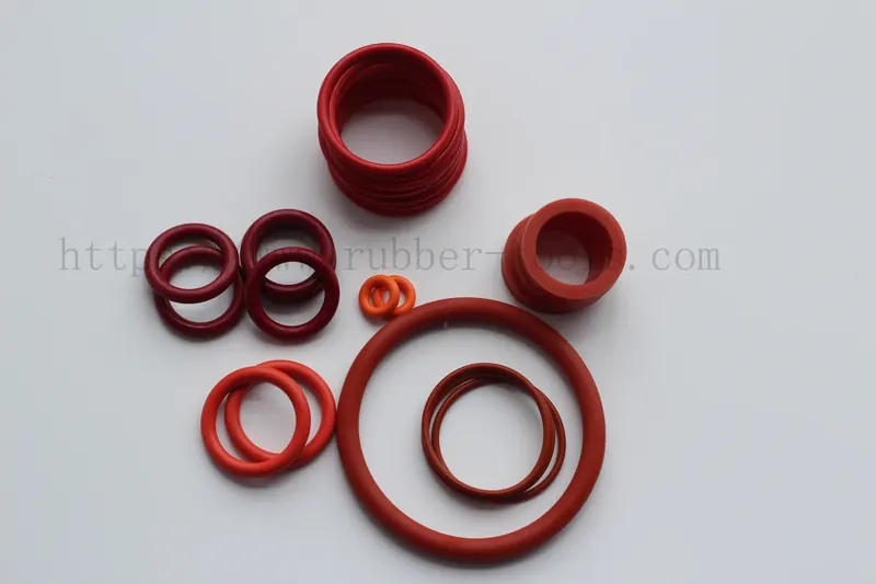 Assorted red silicone O-rings in several diameters on a light surface